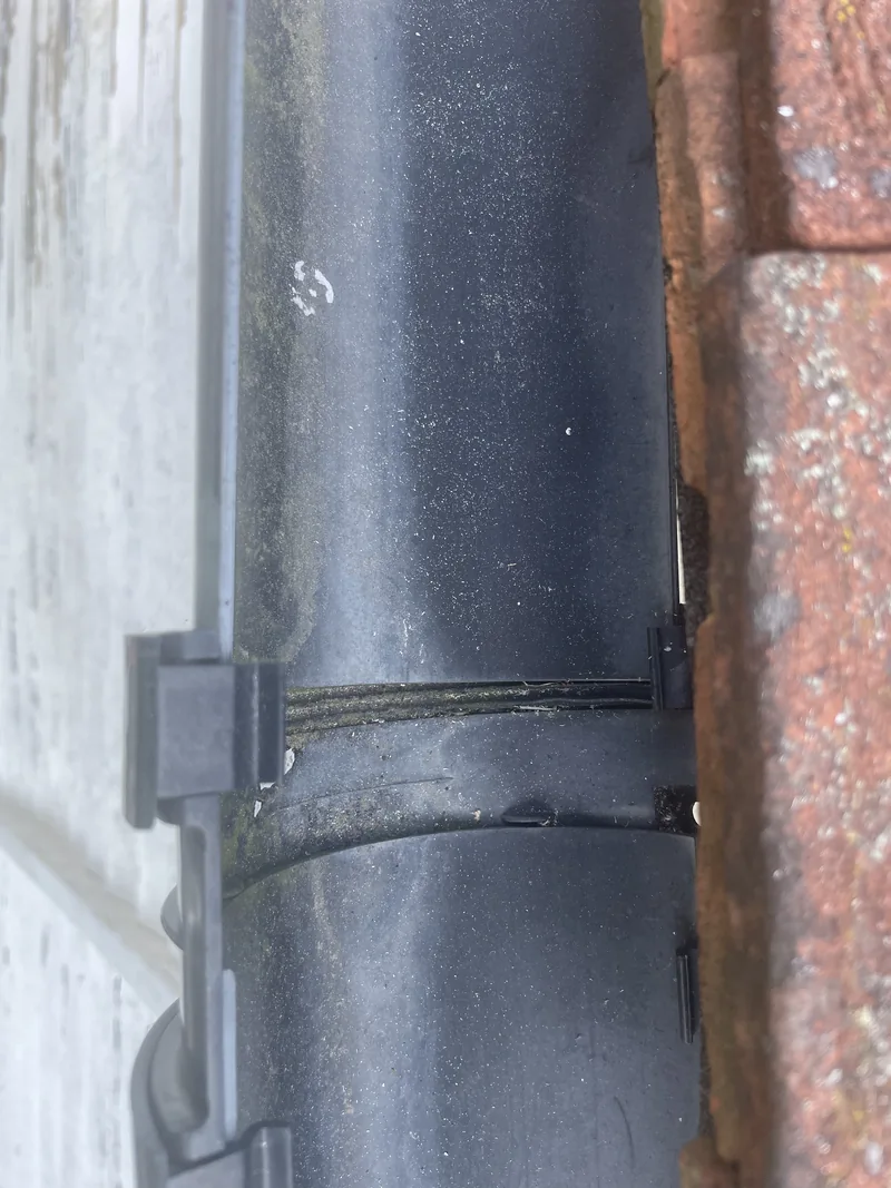 Plastic gutter displaced at a gutter union, with the joint and retaining clip visible