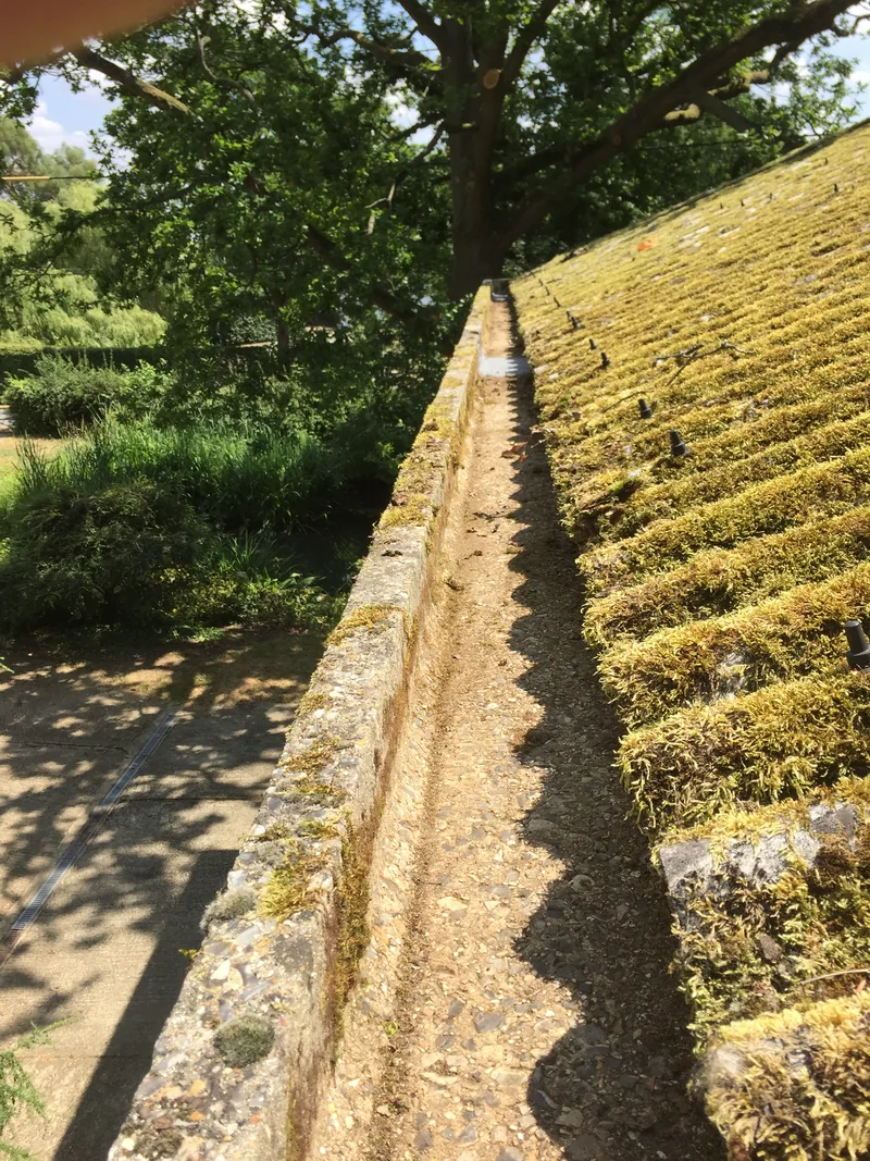 The same long roof drainage channel with the accumulated debris removed