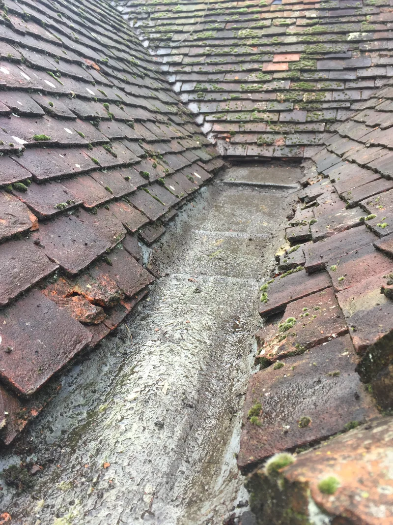 The same tiled roof valley with the accumulated vegetation removed